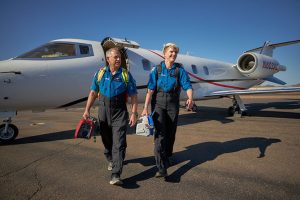 zoomed out two crew members leaving the Learjet after a flight