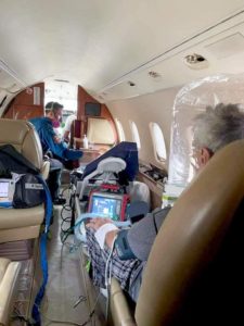 patient on Learjet wearing Amron NIV hood for infectious disease transport