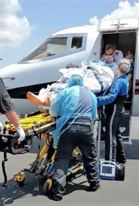 the medical team transporting the patient into the aircraft for flight