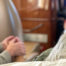 loved one holding the hand of a hospice patient during a medical flight